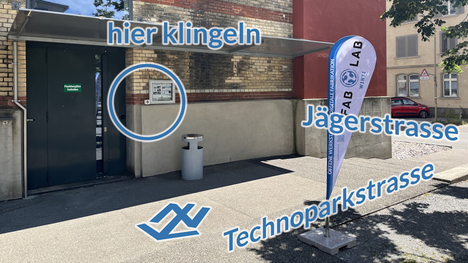 Foto des Eingangs in der Ecke Jägerstrasse/Technoparkstrasse mit Klingelknopf neben der Tür und FabLab-Flagge davor
